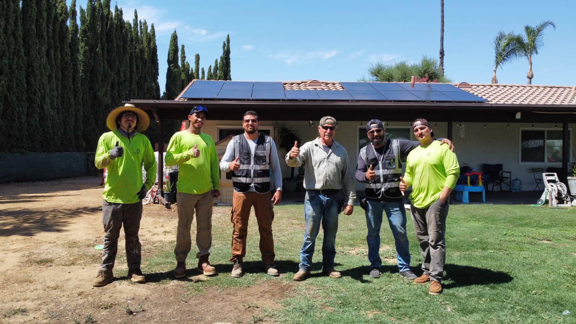 Guyou Roofing & Solar install crew in front of a completed rooftop solar system